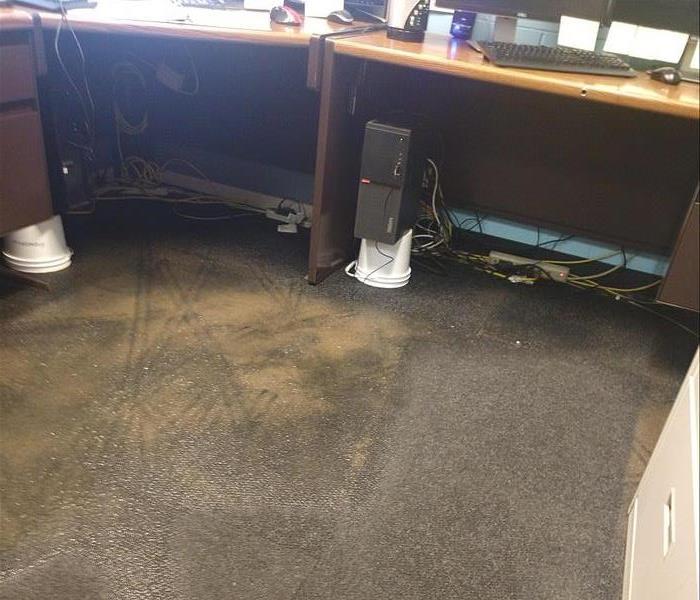 office with computers on desk, carpet soaked in water 
