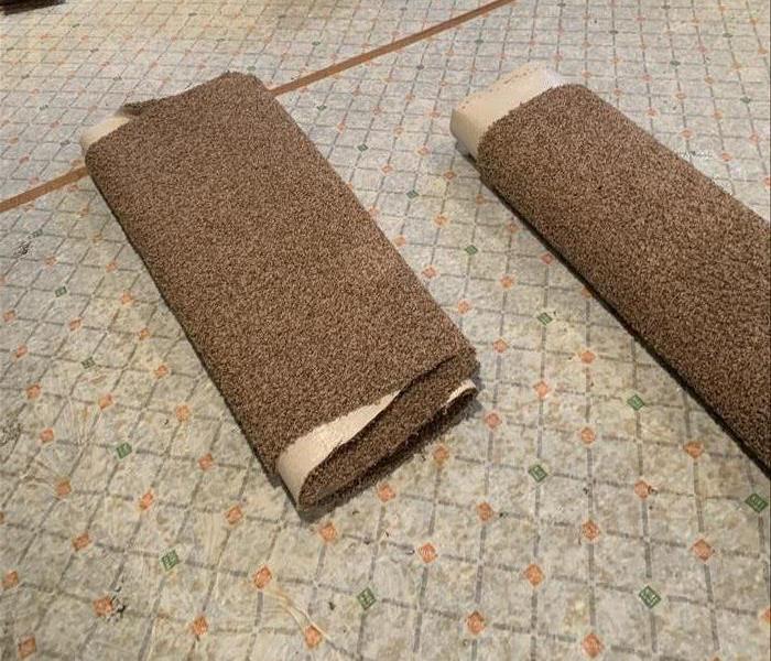 Carpet padding with pieces rolled up carpet on top