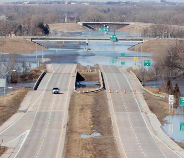 large highway covered in deep water so vehicles cannot drive through